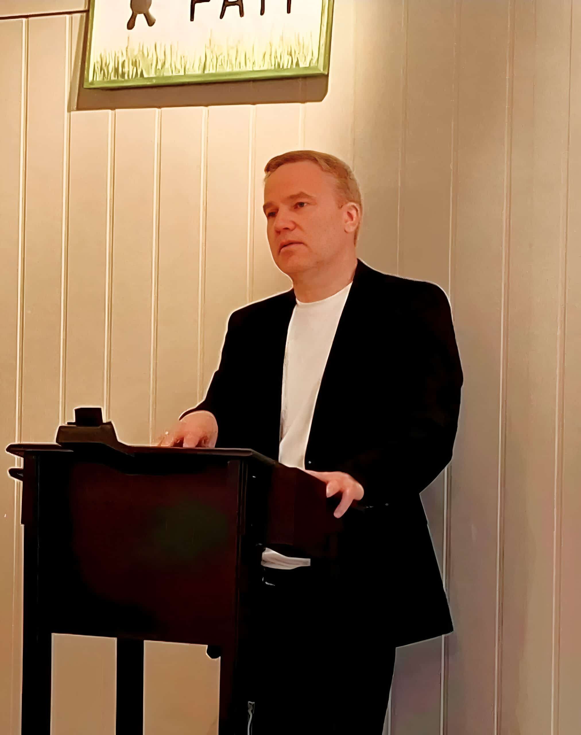 Bilde av en mann som spiller piano under et selskap eller event i Norge, fokus på musikk og underholdning.