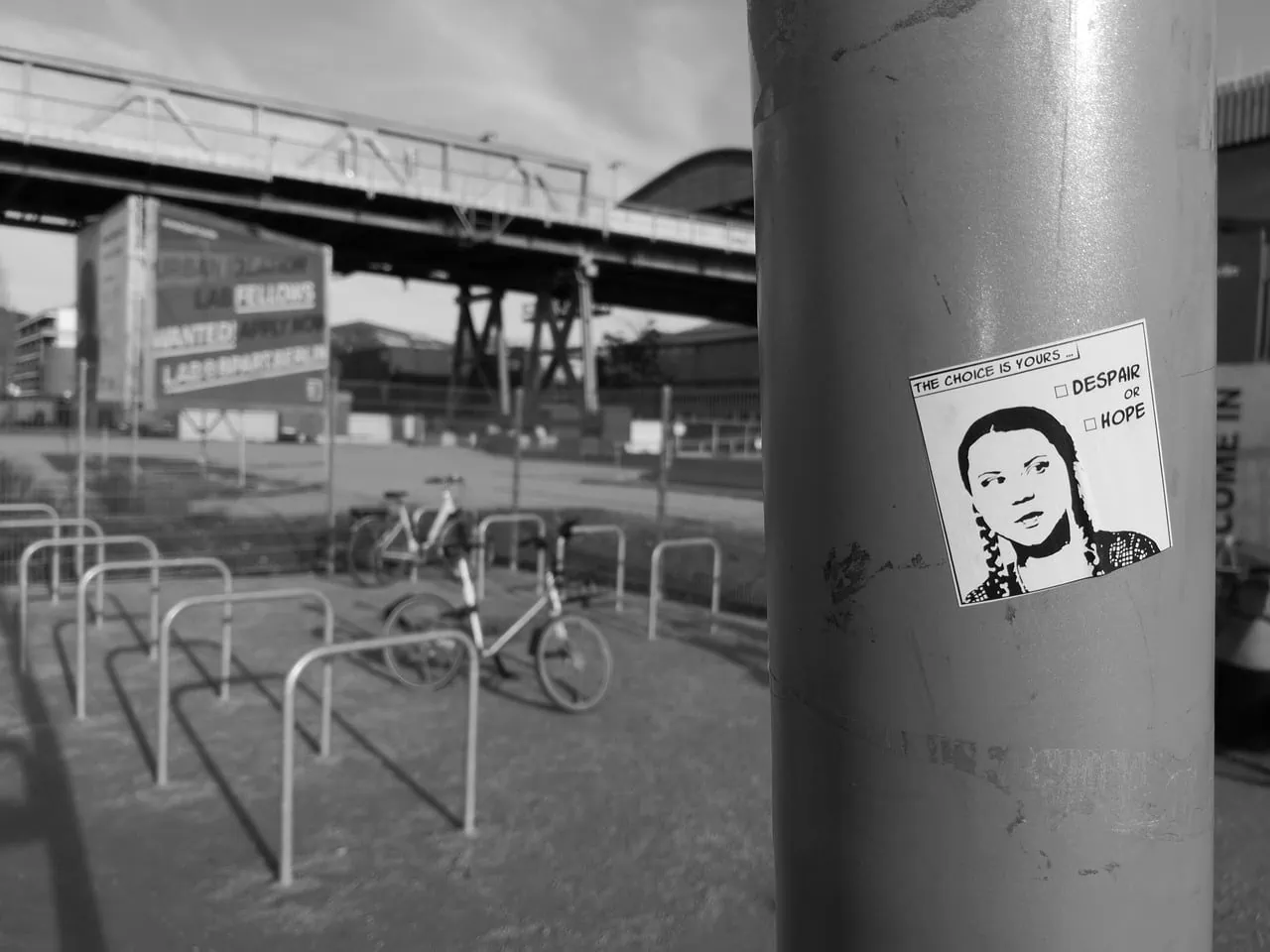 Stickers med valg om håp eller håp på en bygate i svart-hvitt, fokus på inspirerende motiv og urban miljø.