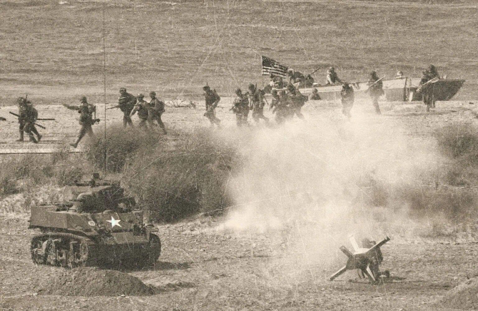 Utsnitt av amerikanske soldater under slag, med en tank i forgrunnen og to båter i bakgrunnen, som illustrasjon av militæroperasjoner under krig i en historisk svart-hvitt-stil.